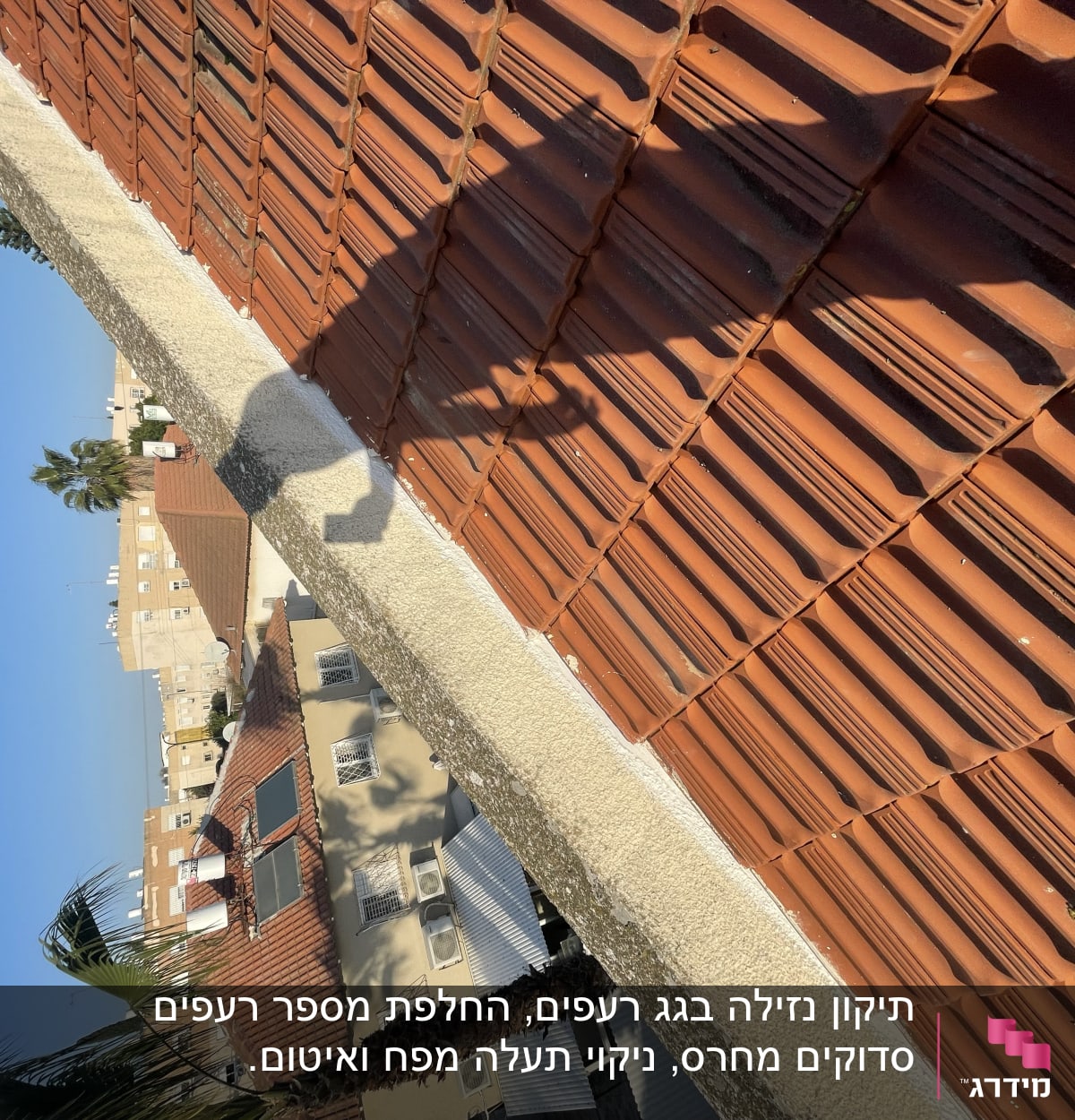 רעפים אדומים על גג עם צל של אדם